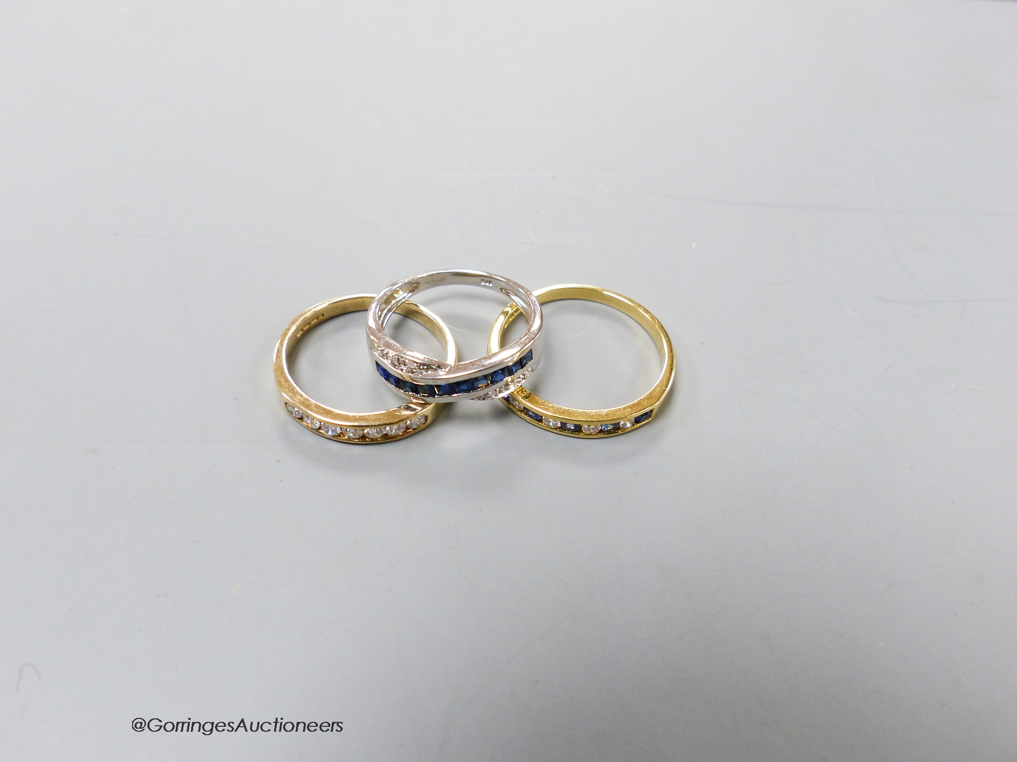 A modern 18ct gold and channel set sapphire and diamond half hoop ring, size R, gross 3 grams and two modern 9ct gold and gem set rings, gross 4.3 grams